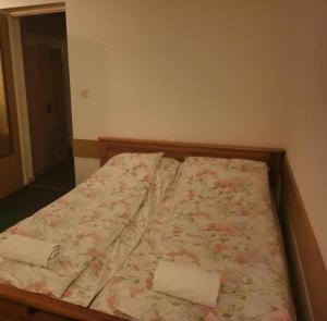 a bed with a floral comforter in a bedroom at Noclegi in Siestrzeń