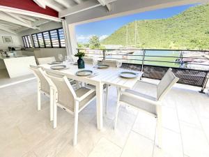 a dining room with a white table and chairs at Marina Beach 2 adjacent apartments marina view in Anse Marcel 