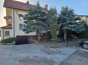 a house with two trees in front of it at Noclegi in Siestrzeń