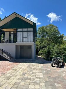 a house with a tractor parked in front of it at Panorama Cottages Tbeti in Shuakhevi