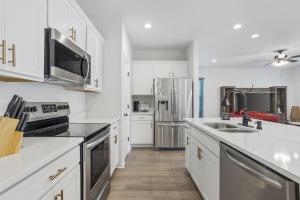 a kitchen with white cabinets and stainless steel appliances at Tiger Tracks Townhome Stay in Baton Rouge - BC1009 in Baton Rouge