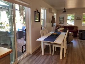 eine Küche und ein Wohnzimmer mit Tisch und Stühlen in der Unterkunft The Cottage on Claire in Point Roberts