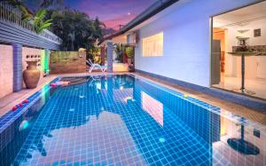 パタヤ・サウスにあるVilla Corner near Walking Street and beachesの青いタイルの家の中のスイミングプール