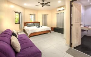 パタヤ・サウスにあるVilla Corner near Walking Street and beachesのベッドルーム(ベッドの前に紫色のソファ付) +20枚の写真