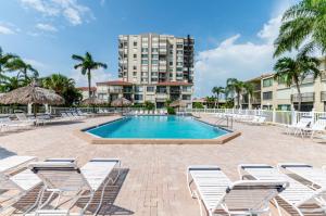 ein Swimmingpool mit Liegestühlen und ein Gebäude in der Unterkunft Palma Del Mar G-606 Beautiful in Point Brittany