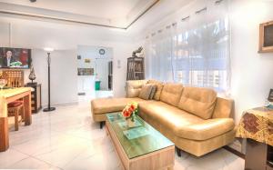 パタヤ・サウスにあるVilla Corner near Walking Street and beachesのソファとテーブルのあるリビングルーム