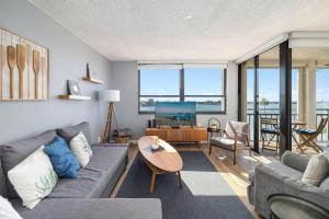 a living room with a couch and a table at Top Floor Bayfront Oasis 2BR 2BA Condo at Casa Del Mar with Stunning Views in Point Brittany
