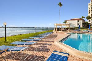 a row of lounge chairs next to the beach at Top Floor Bayfront Oasis 2BR 2BA Condo at Casa Del Mar with Stunning Views in Point Brittany