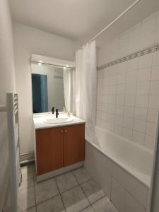 a bathroom with a sink and a bath tub at Appartement - Résidence Vacances calme et tout confort in Touques
