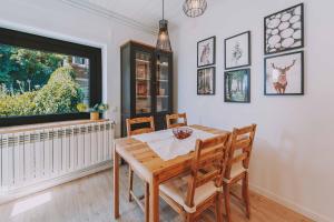 a dining room with a table and chairs and a large window at Cim's Apartments Cerdanya 2 in Bellver de Cerdanya