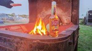 a bottle of beer sitting in a fire pit at Little Lodge Glamping in Halesworth