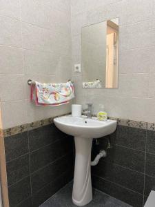 a bathroom with a sink and a mirror at New Cozy Apartment in Bishkek +7 photos