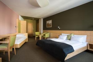 a hotel room with a bed and a table and chairs at Gasthof Traube in San Lorenzo di Sebato