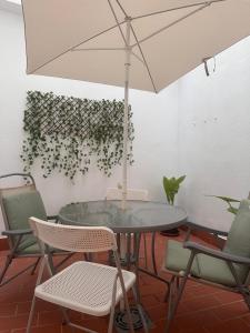 a table and chairs with an umbrella in a room at Apartamento Alegría in Antequera