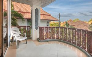 a balcony with a white chair and a fence at Villa Madee near Walking Street and beaches in Pattaya South