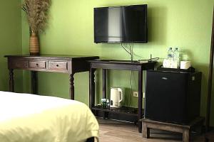 a bedroom with a bed and a tv on a wall at Elegant Lanna Guesthouse in Chiang Mai