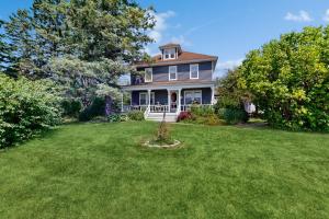 una casa con un ampio giardino con erba verde di Acadia Lights Cottage a Sullivan