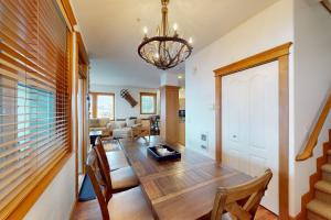 Un comedor y una sala de estar con mesa y sillas. en Tree Tops 12, en Big White