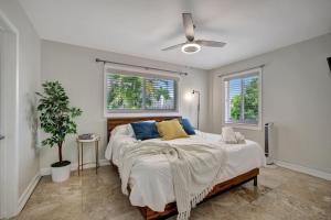 a bedroom with a large bed and two windows at Stylish 2br 3ba with Heated Pool plus Beach Walkable in Fort Lauderdale