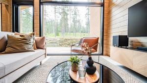 a living room with a couch and a glass table at Villa Sirius, Äkäslompolo, Ylläs in Äkäslompolo