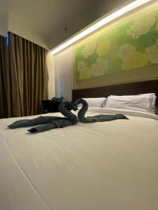 zwei Schlangen liegen auf einem Bett in einem Hotelzimmer in der Unterkunft PJ Centrestage Hotel walkable to LRT-2 in Petaling Jaya
