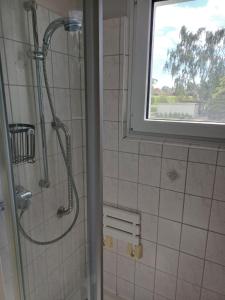 a shower in a bathroom with a window at Ferienwohnung Marienberg in Nordstemmen