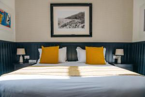 a bedroom with a large bed with yellow pillows at 27 The Terrace in St Ives