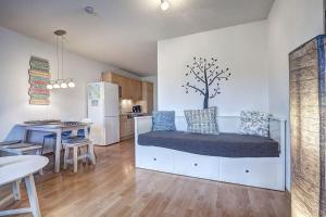 Una sala de estar con una cama y una cocina. en Fewo Henri, en Zempin