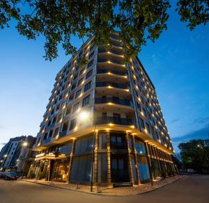 ゴリにあるGori Palace Apartmentsのたくさんの窓がある高い建物
