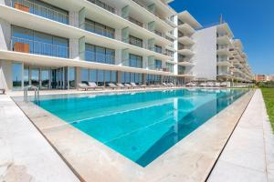 a swimming pool in front of a building at Cond BAYLINE BEACH & SPA RETREAT - Linguado BY BEDZY in Armação de Pêra