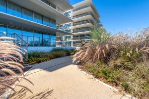 an apartment building with plants in front of it at Cond BAYLINE BEACH & SPA RETREAT - Linguado BY BEDZY in Armação de Pêra