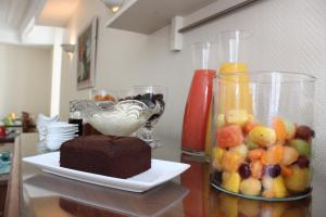 a table with a chocolate cake and a vase of fruit at Hotel Auberge des Remparts in Laval