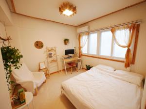 a bedroom with a bed and a desk and a window at Haeundae Haeridan Stay in Busan
