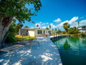 a swimming pool with benches next to a house at Fish Camp in Sugarloaf Shores