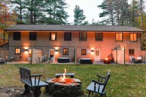 a large house with a fire pit in the yard at Heathers Hot tub Hideaway in Middle Grove