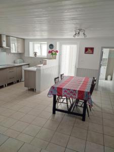 a kitchen with a table in the middle of a room at hortensia 8 in Saint-Étienne-de-Mer-Morte +2 photos