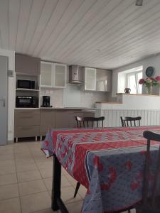 a kitchen with a table with a red table cloth on it at hortensia 8 in Saint-Étienne-de-Mer-Morte