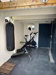 a room with a gym with a bike and a door at Reve Divin T2 en R/C parking-bagagerie-salle sport-barbecue in Lourdes