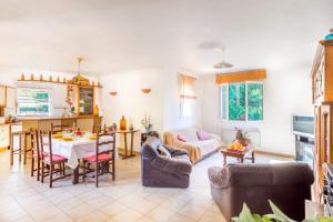 una cucina e un soggiorno con tavolo e sedie di Villa Mas des Fleurs by Villa Plus a Le Tignet