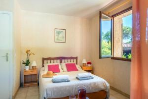 una camera da letto con un letto con due cuscini e una finestra di Villa Mas des Fleurs by Villa Plus a Le Tignet