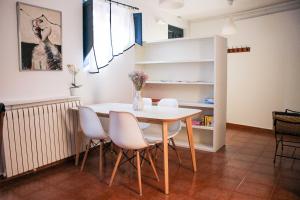 a dining room with a table and white chairs at El 8 de Serranos - Bajo - Casa con garaje in León