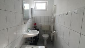 a white bathroom with a toilet and a sink at Kleine Ferienwohnung in ruhiger Lage in Herzogenrath +7 photos