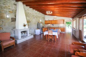 una cucina e una sala da pranzo con tavolo e camino di Casa da Pedra ad Aborim