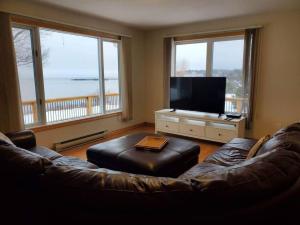 セント・ジョンにあるBungalow on The Bay in Lornevilleのリビングルーム(革張りのソファ、薄型テレビ付)
