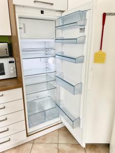 a refrigerator with empty shelves in a kitchen at alscher's holiday home in Interlaken