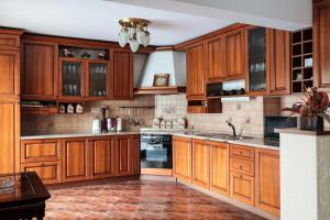 a kitchen with wooden cabinets and stainless steel appliances at AMARI PARK Residence in Golyama Zhelyazna