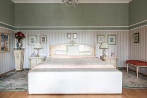 a bedroom with a large white bed and two tables at AMARI PARK Residence in Golyama Zhelyazna