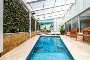 a swimming pool in a house with a glass roof at Hotel Beit Maimon in Zikhron Ya‘aqov