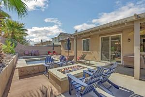 un patio con sillas azules y una hoguera en Serene Private Pool - Jacuzzi - BBQ - Gated Community, en Indio