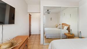 a bedroom with a bed and a mirror at Beachfront Serene Apt at Victoria del Mar 3F in Stella